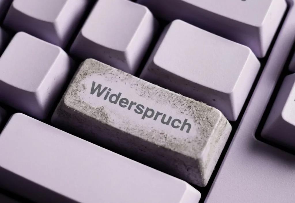 Einzelne eingestaubte Tastatur-Taste mit der Aufschrift Widerspruch